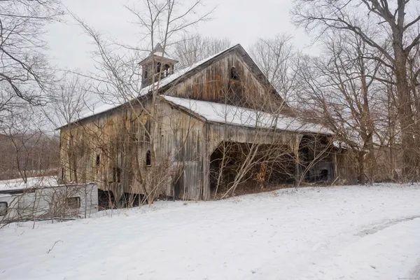 a front view of a house with a yard covered in snow