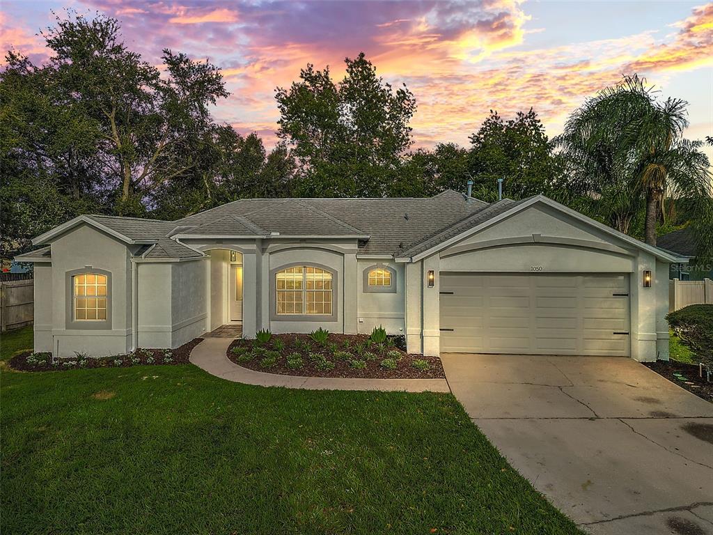 1050 High Ridge Court Minneola, FL 34715 - Photo 1 of 1 a front view of a house with a yard and garage