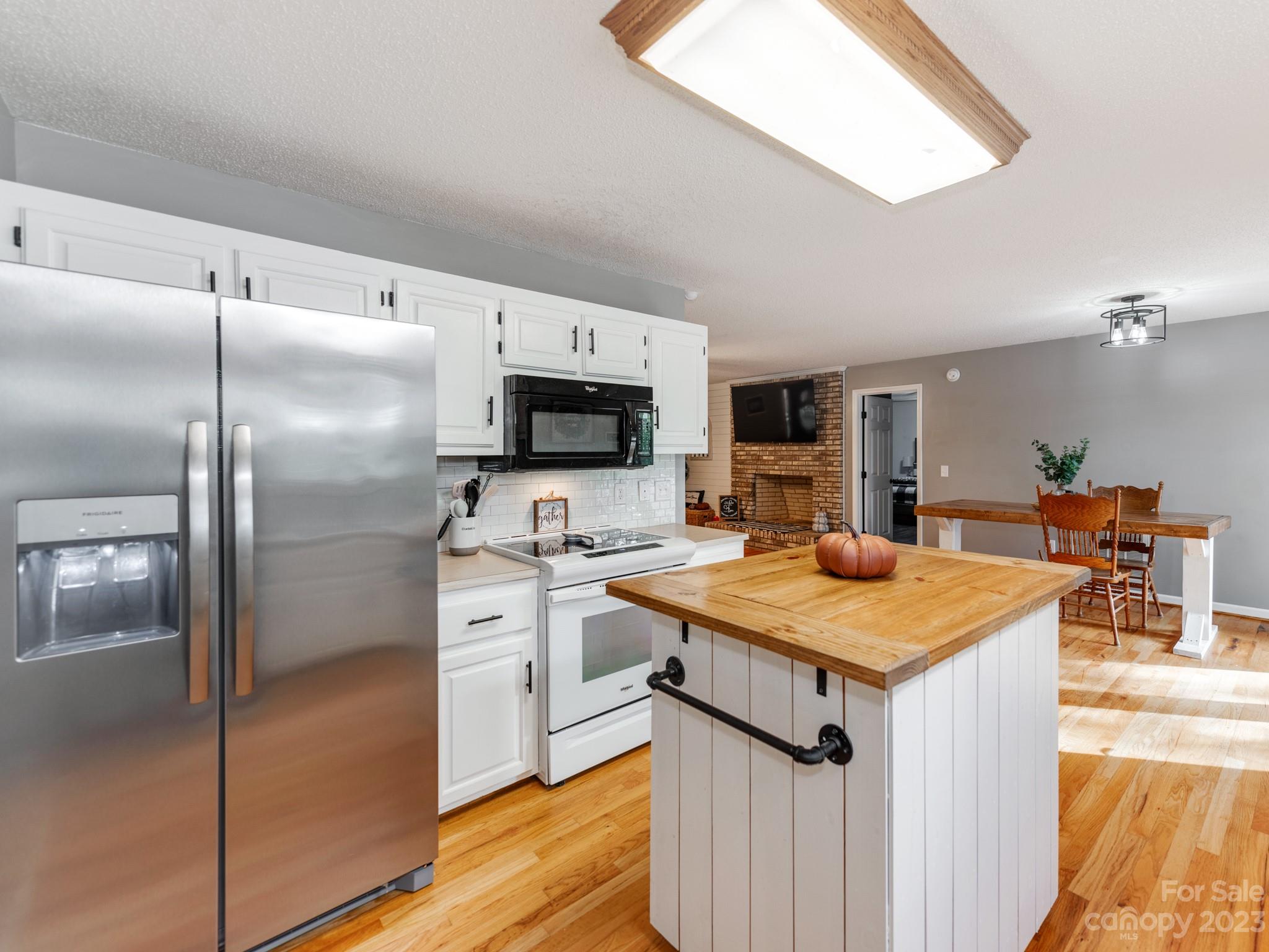 33702 Western Road Albemarle, NC 28001 - Photo 15 of 42 a kitchen with a refrigerator a microwave oven on a table and chairs