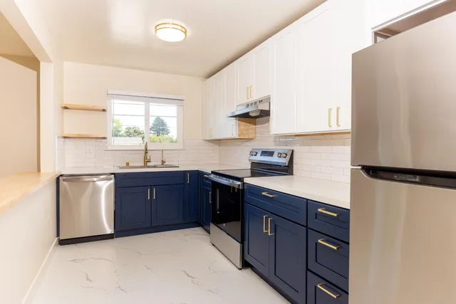 a kitchen with granite countertop a stove sink and cabinets