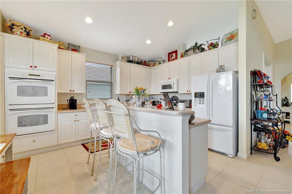 5195 Southeast Graham Drive Stuart, FL 34997 - Photo 18 of 52 a kitchen with stainless steel appliances a refrigerator and cabinets