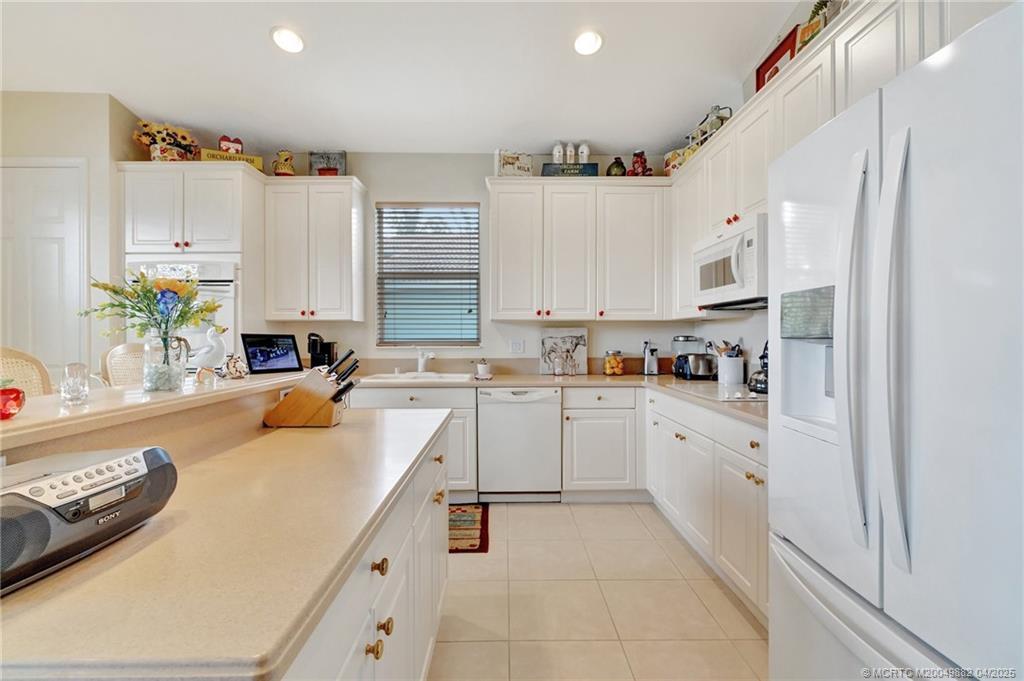 5195 Southeast Graham Drive Stuart, FL 34997 - Photo 19 of 52 a kitchen with a sink window and white cabinets