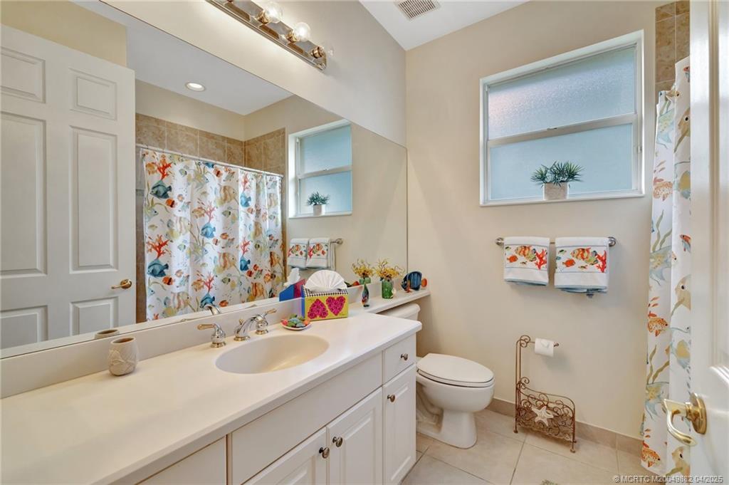 5195 Southeast Graham Drive Stuart, FL 34997 - Photo 24 of 52 a bathroom with a toilet sink and mirror