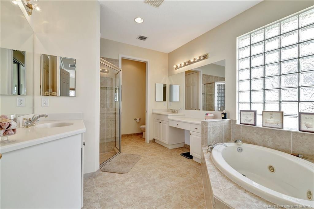 5195 Southeast Graham Drive Stuart, FL 34997 - Photo 31 of 52 a bathroom with a tub sink shower and mirror