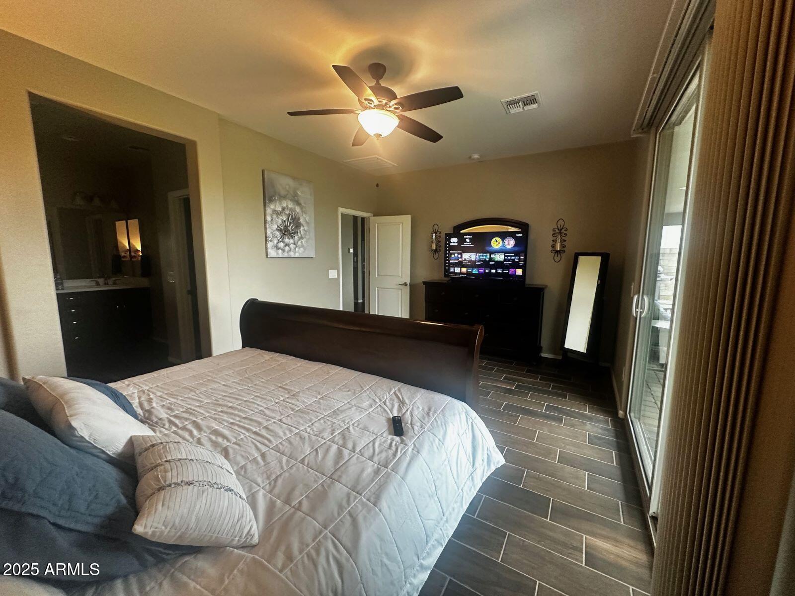 22503 East Calle De Flores Queen Creek, AZ 85142 - Photo 24 of 57 a bedroom with a large bed and a chandelier