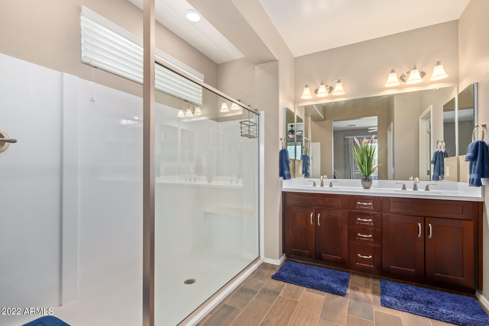 22503 East Calle De Flores Queen Creek, AZ 85142 - Photo 27 of 57 a spacious bathroom with a glass door shower a sink and a mirror