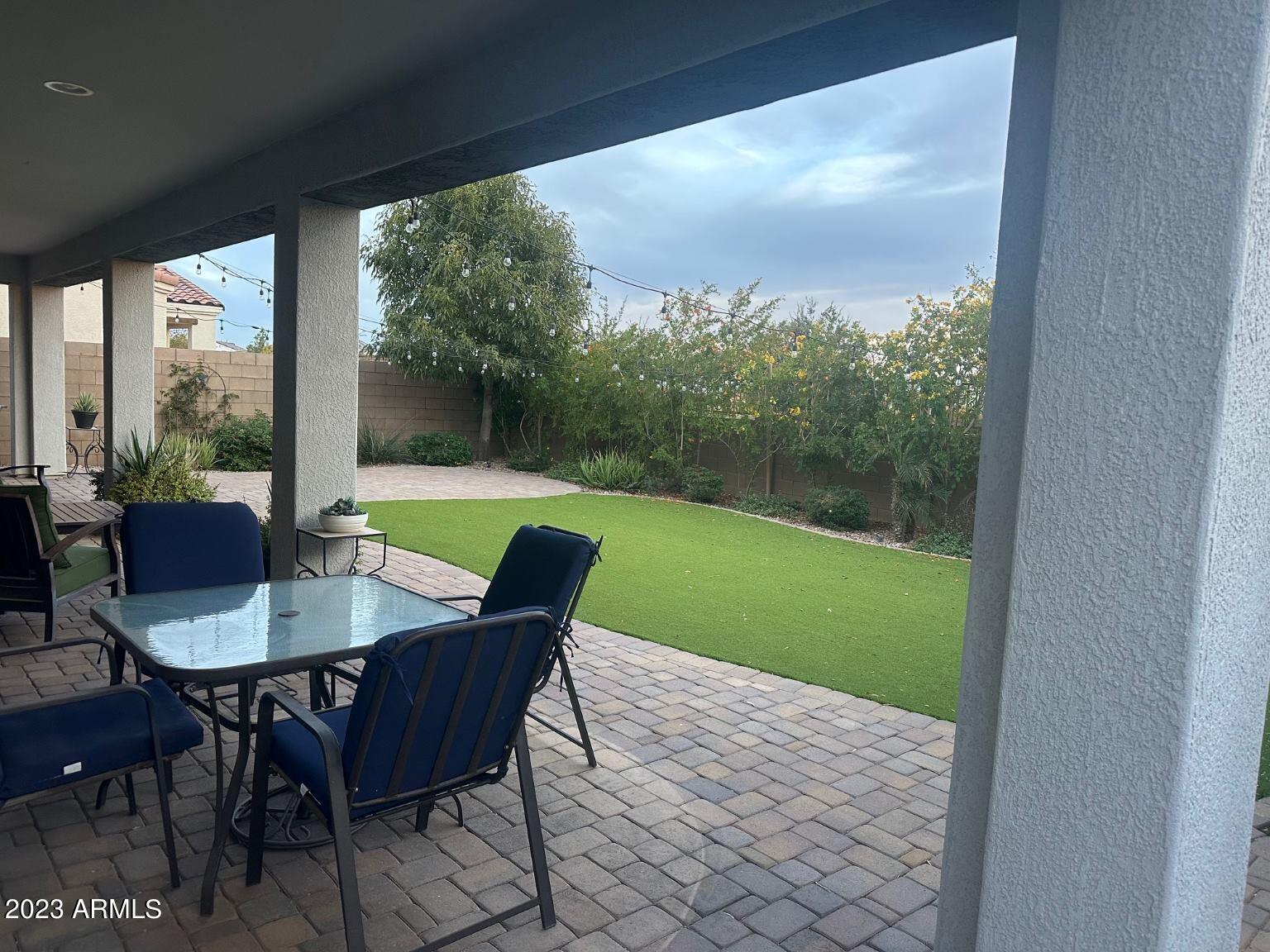 22503 East Calle De Flores Queen Creek, AZ 85142 - Photo 37 of 57 a view of a porch with a table chairs and a yard