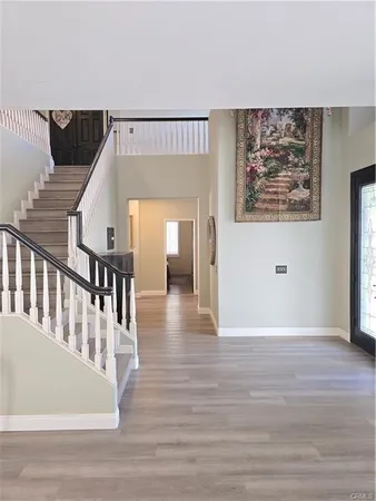 a view of a hallway with wooden floor and staircase