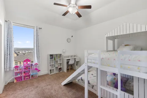 a bedroom with a bed a desk and book shelfs