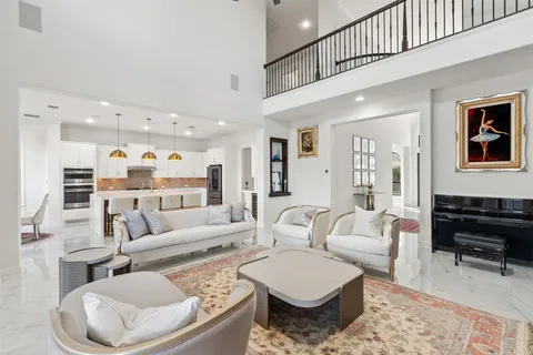 a living room with furniture kitchen view and large windows