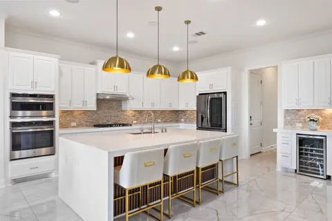 a kitchen with a sink a counter space appliances and cabinets