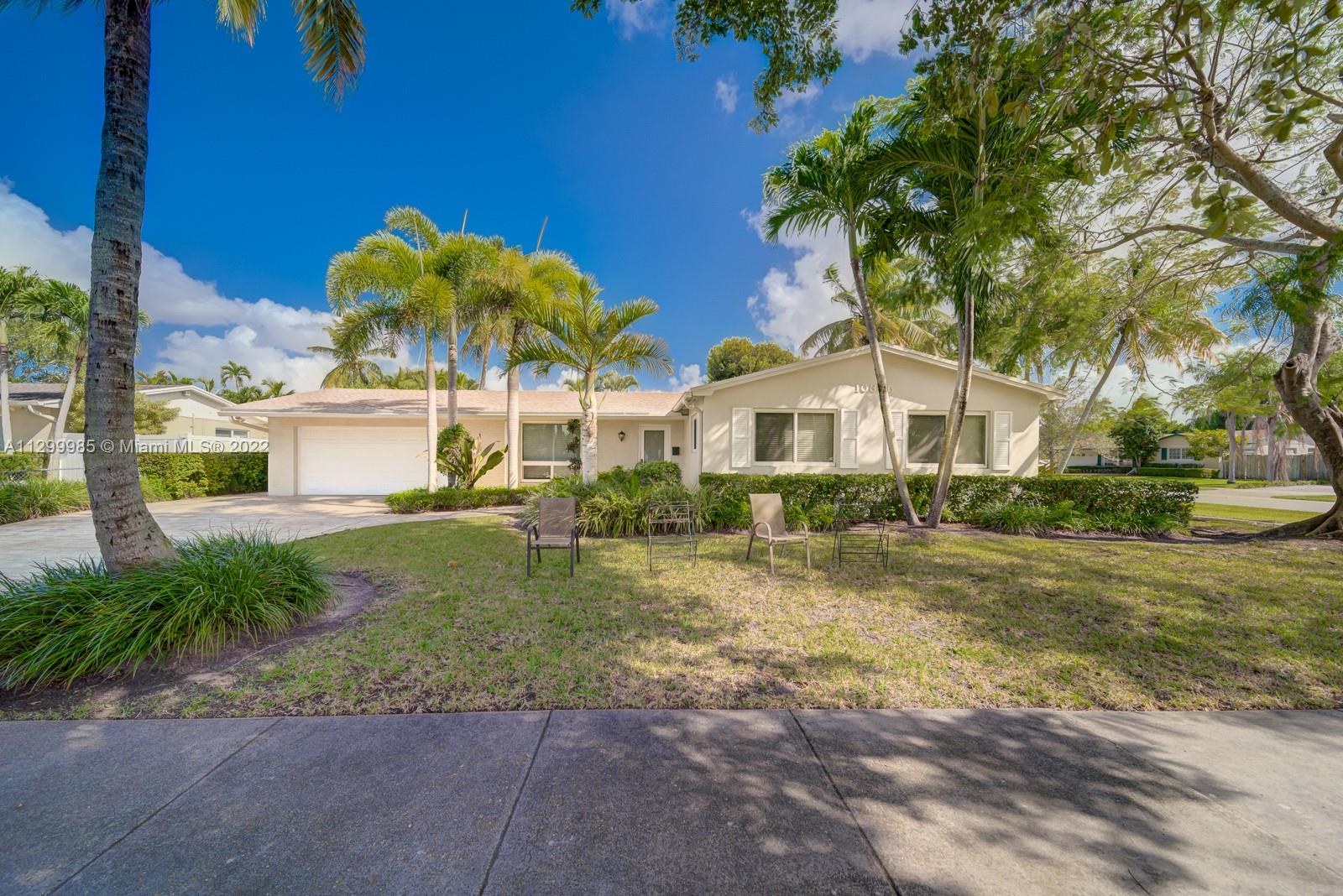 10345 Southwest 97th Street, Unit 10345 Miami, FL 33176 - Photo 2 of 4 a front view of a house with a yard and garage