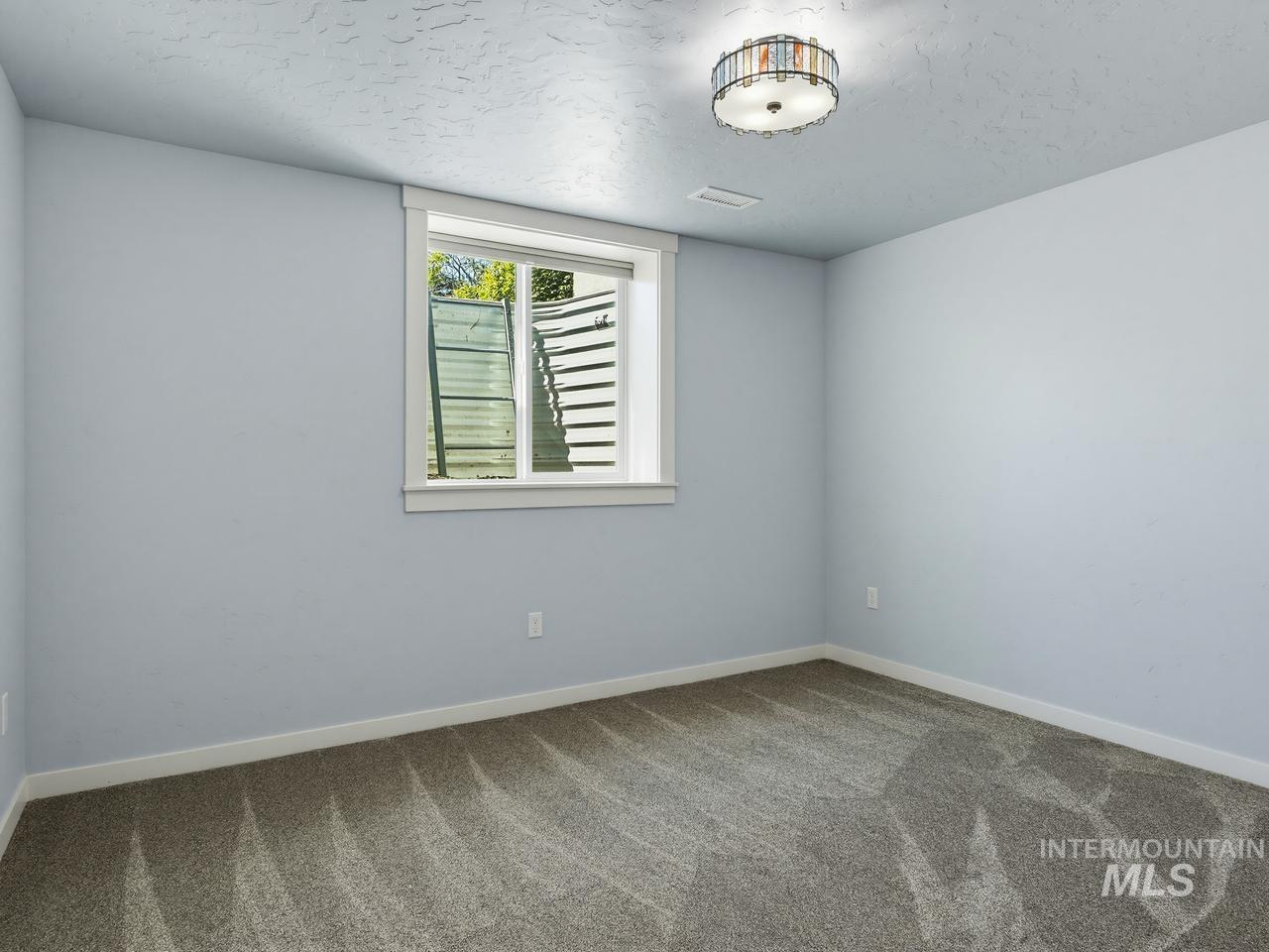 4950 West Columbia Road Nampa, ID 83687 - Photo 36 of 50 Room featuring light blue walls, gray patterned carpet, and white baseboards