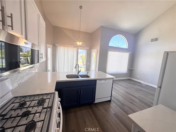 a large kitchen with a large counter top stainless steel appliances and window