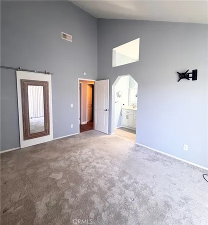 a spacious bathroom with a double vanity sink a large mirror a toilet and a shower