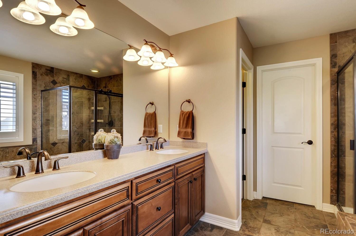 10560 Sundial Rim Road Highlands Ranch, CO 80126 - Photo 14 of 27 a bathroom with a double vanity sink mirror and chandelier