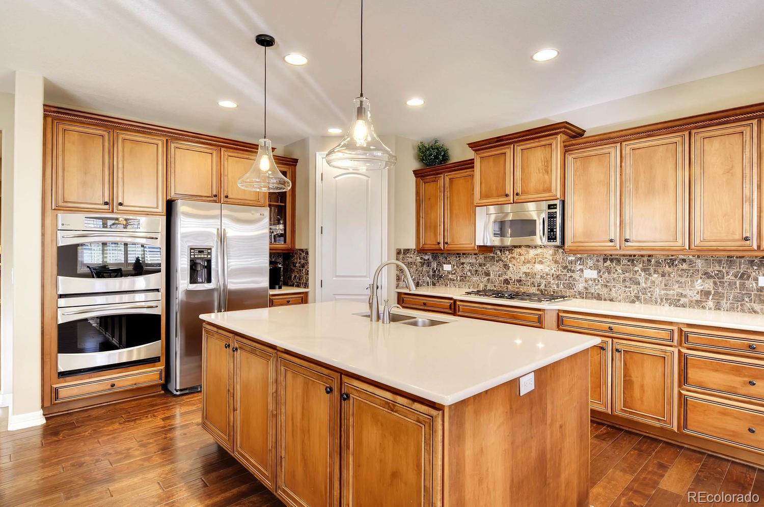 10560 Sundial Rim Road Highlands Ranch, CO 80126 - Photo 2 of 27 a kitchen with stainless steel appliances granite countertop a sink and a refrigerator
