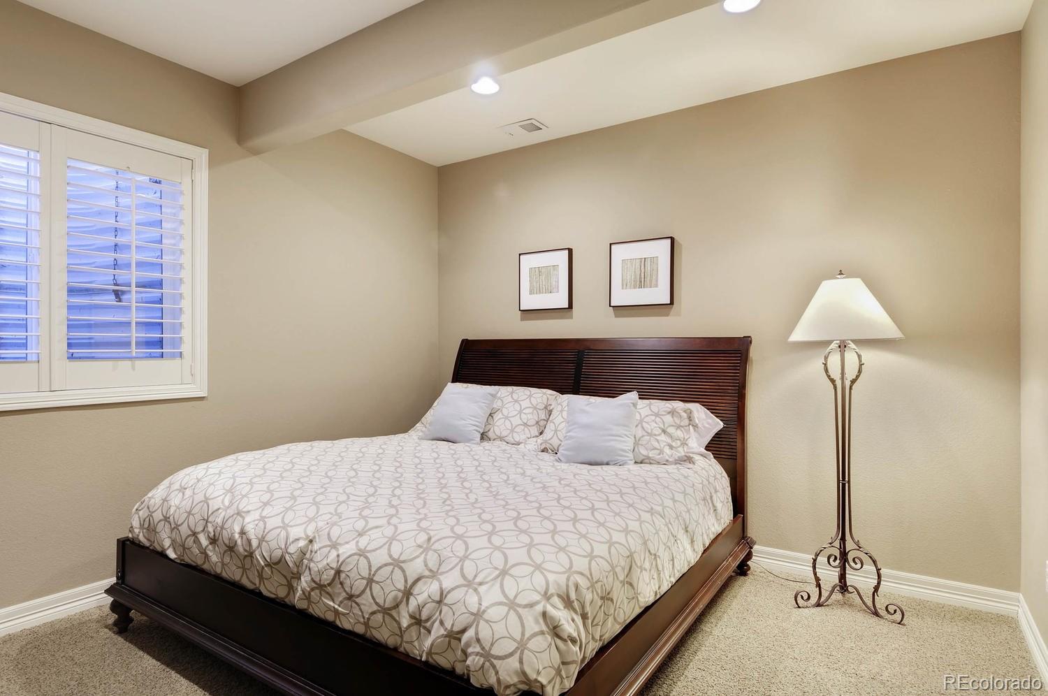 10560 Sundial Rim Road Highlands Ranch, CO 80126 - Photo 21 of 27 a bedroom with a bed and lamp