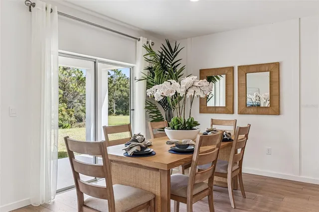 a dining room with furniture potted plants and wooden floor