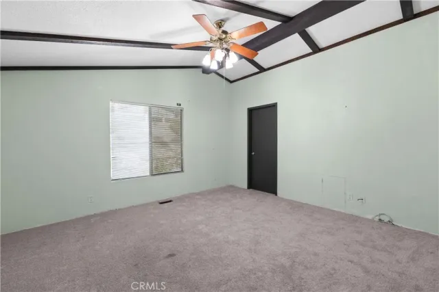 a view of a room with a ceiling fan and window