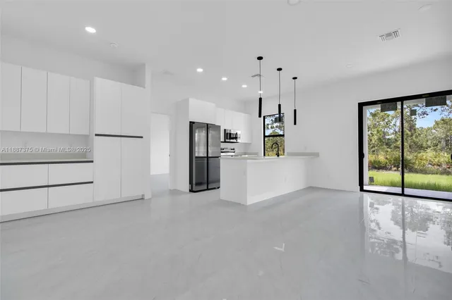 a view of a kitchen with a refrigerator wooden cabinets and a window