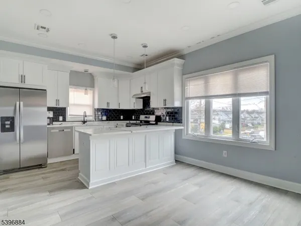 a kitchen with granite countertop white cabinets and stainless steel appliances