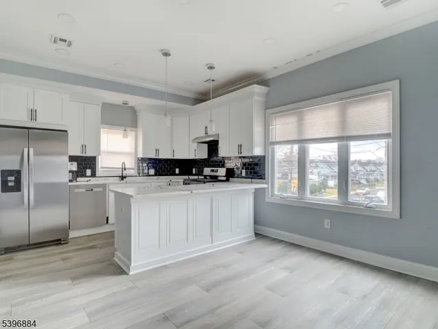 a kitchen with granite countertop white cabinets and stainless steel appliances