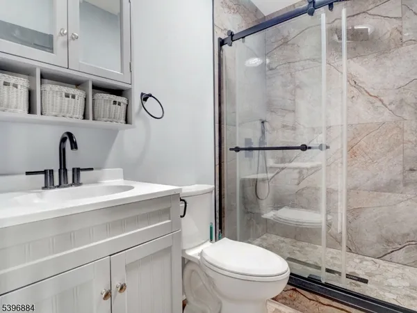 a bathroom with a sink a toilet and shower