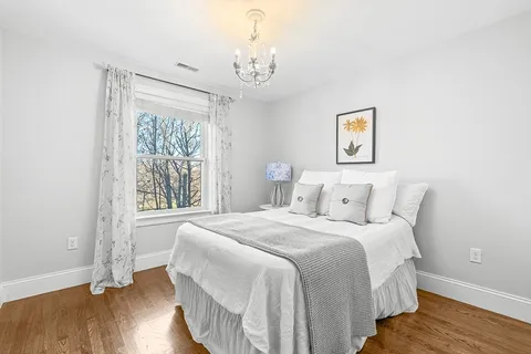a bedroom with a bed and wooden floor