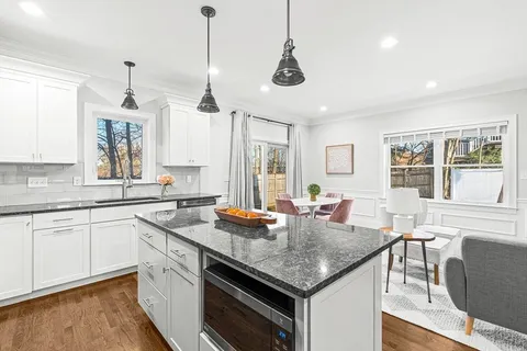 a kitchen with granite countertop kitchen island a sink and a stove