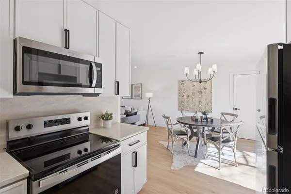 a kitchen with stainless steel appliances a stove a table and chairs