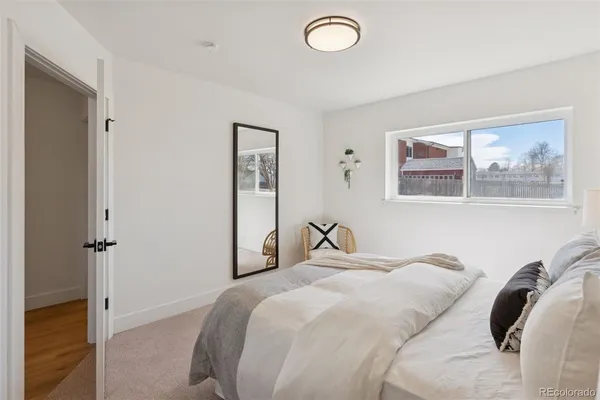 a bedroom with a bed and a painting on the wall