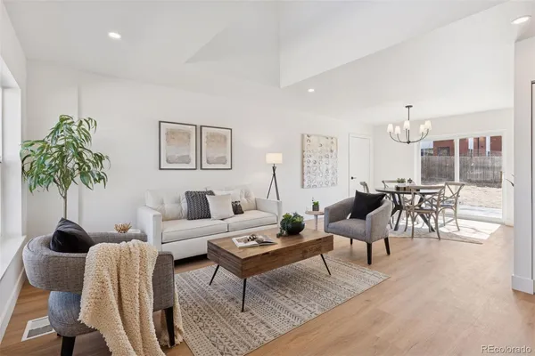 a living room with furniture a table and a potted plant