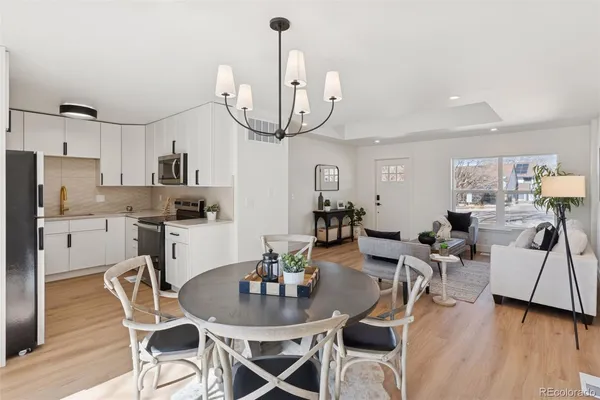 a dining room with furniture a chandelier and wooden floor