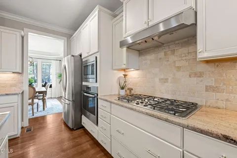 a kitchen with stainless steel appliances granite countertop a refrigerator and a stove