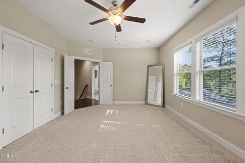 a view of a big room with windows and chandelier fan