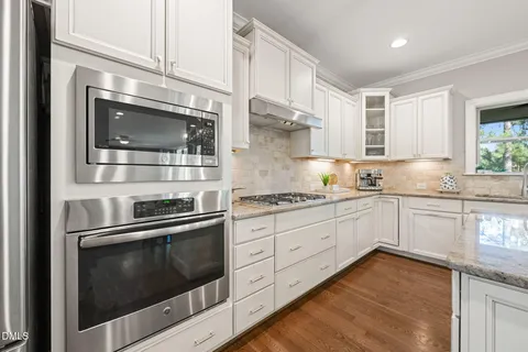 a kitchen with granite countertop cabinets stainless steel appliances and a counter space