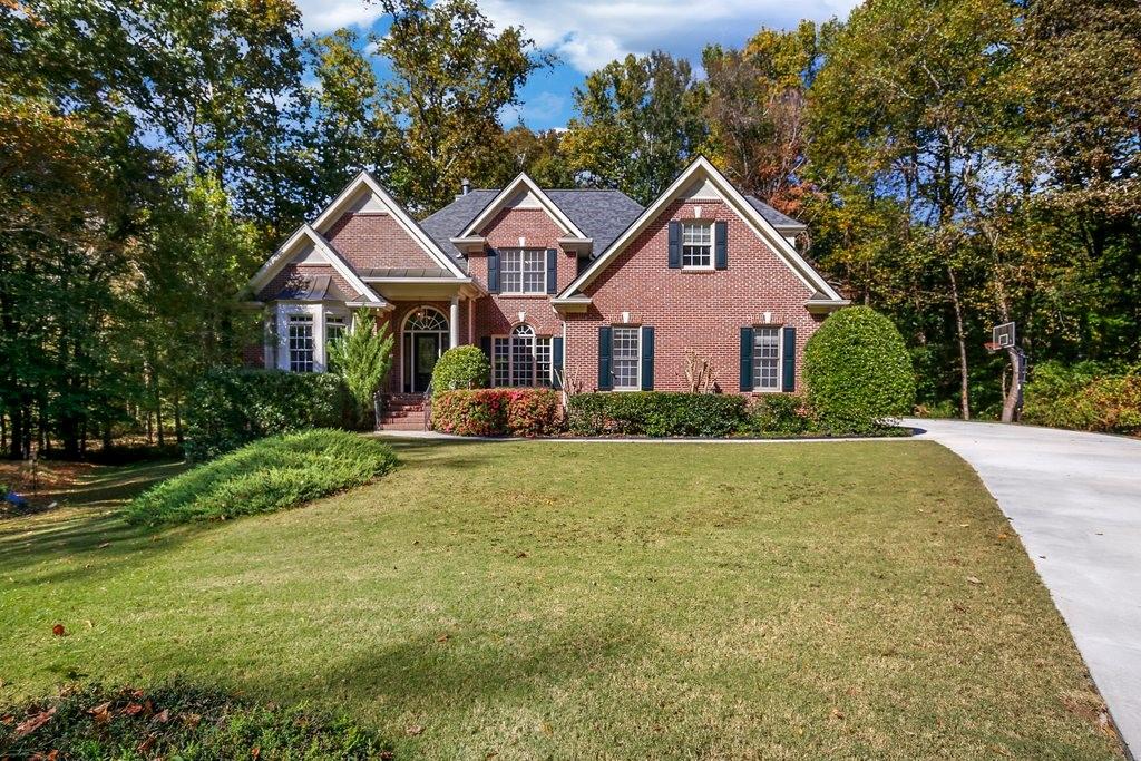 a front view of a house with yard and green space
