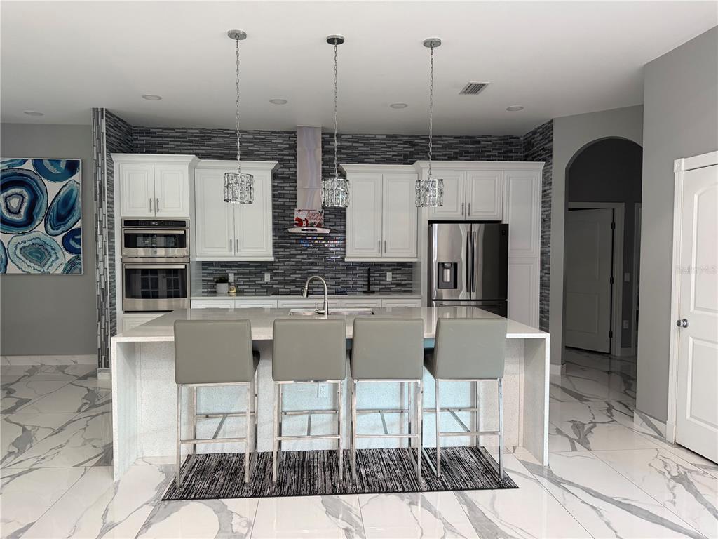 5315 3rd Bradenton, FL 34203 - Photo 8 of 41 a kitchen with stainless steel appliances kitchen island granite countertop a table and chairs in it