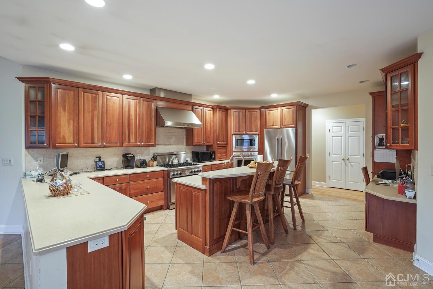 73 Davidson's Mill Road North Brunswick, NJ 08902 - Photo 19 of 51 a kitchen with stainless steel appliances kitchen island granite countertop a table chairs sink and cabinets