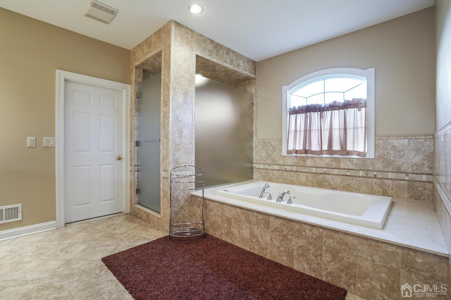 73 Davidson's Mill Road North Brunswick, NJ 08902 - Photo 32 of 51 a spacious bathroom with a tub a sink and a mirror