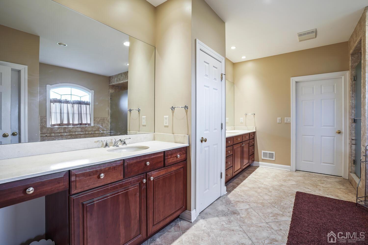 73 Davidson's Mill Road North Brunswick, NJ 08902 - Photo 33 of 51 a spacious bathroom with a double vanity sink a large mirror and a shower