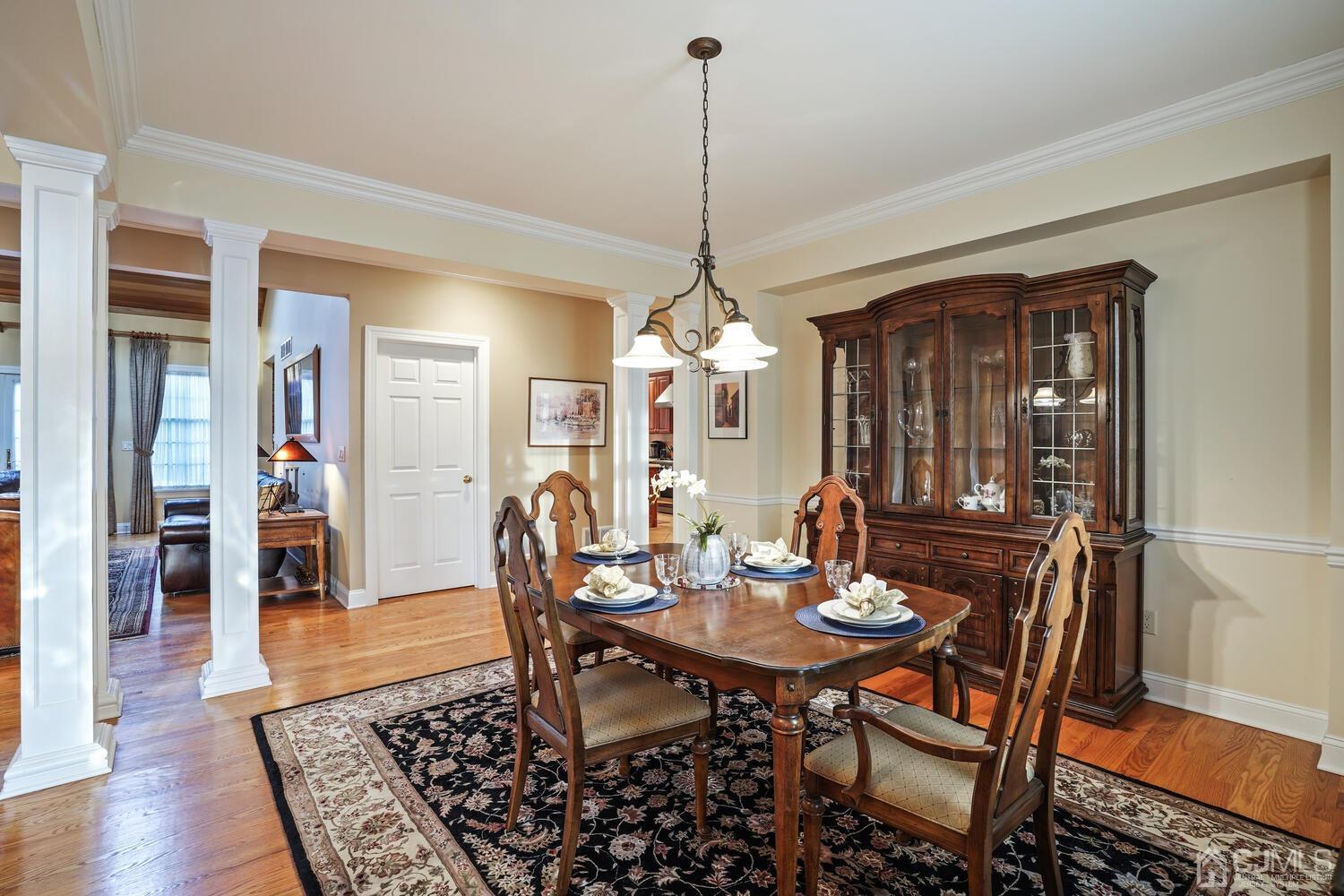 73 Davidson's Mill Road North Brunswick, NJ 08902 - Photo 7 of 51 a dining room with furniture wooden floor a rug a potted plant and a chandelier