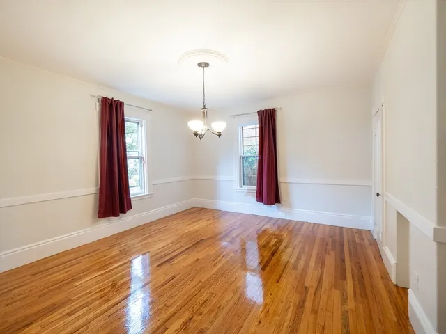 a view of a room with wooden floor staircase and a kitchen