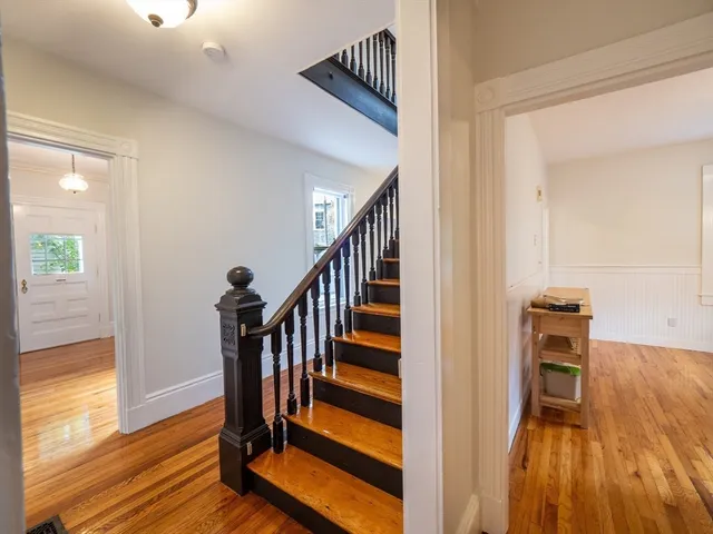 a view of a hallway with wooden floor and staircase