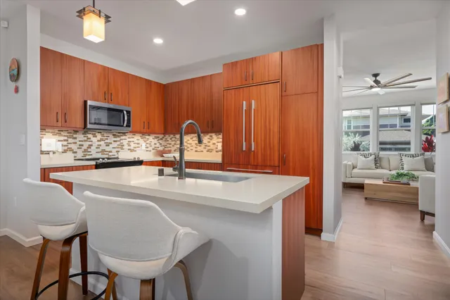 a kitchen with stainless steel appliances granite countertop a sink a stove and a wooden floors