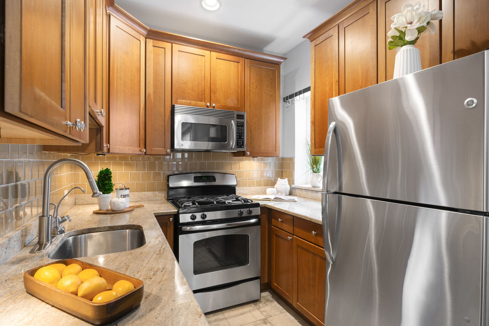 629 West Sheridan Road, Unit 1D Chicago, IL 60613 - Photo 8 of 17 a kitchen with stainless steel appliances granite countertop a refrigerator a stove a sink and a microwave