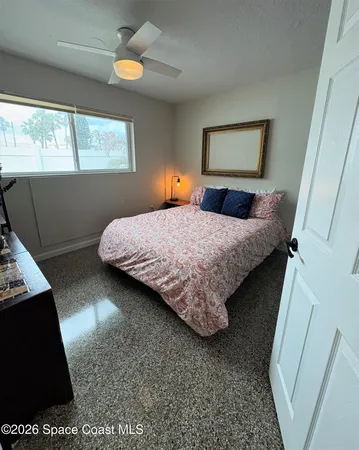 a bedroom with a bed and a flat tv screen on dresser