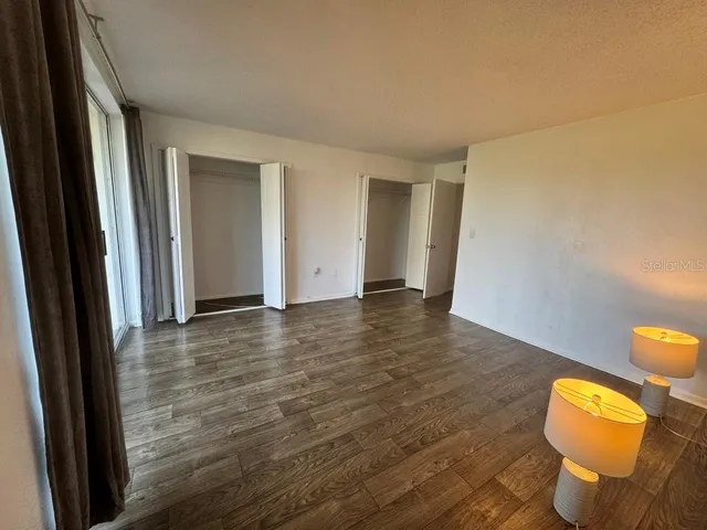 a kitchen with stainless steel appliances a refrigerator a stove a microwave and island with wooden floor