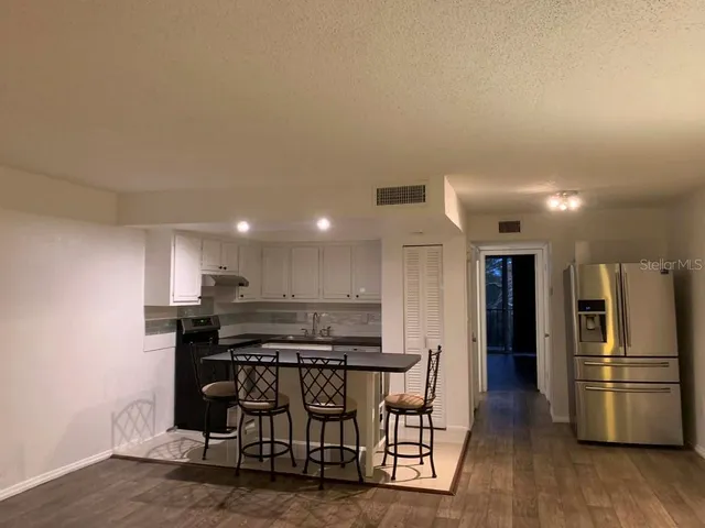 a view of a room with wooden floor and a table